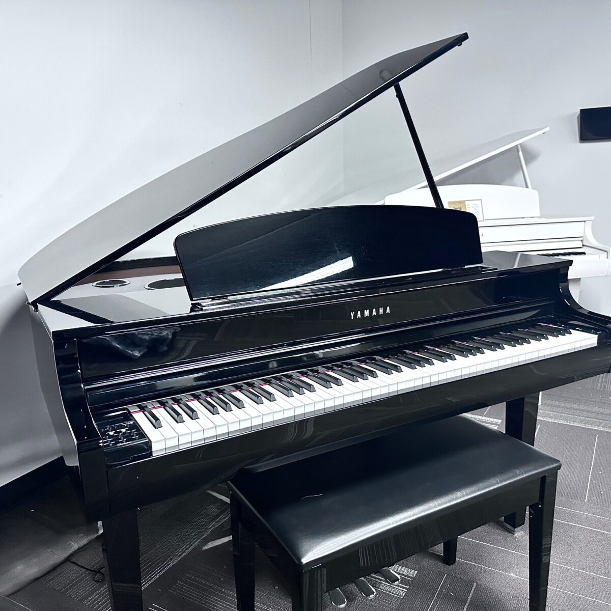 Yamaha grand piano with black glossy finish in a showroom.