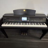 Yamaha Clavinova digital piano with dark wood finish in a showroom setting.