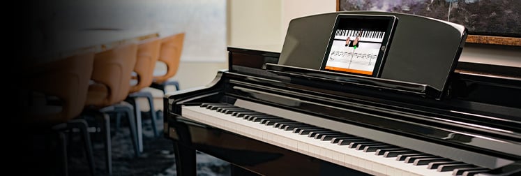 Yamaha Clavinova digital piano with integrated display screen for interactive learning, showcased in elegant black finish.