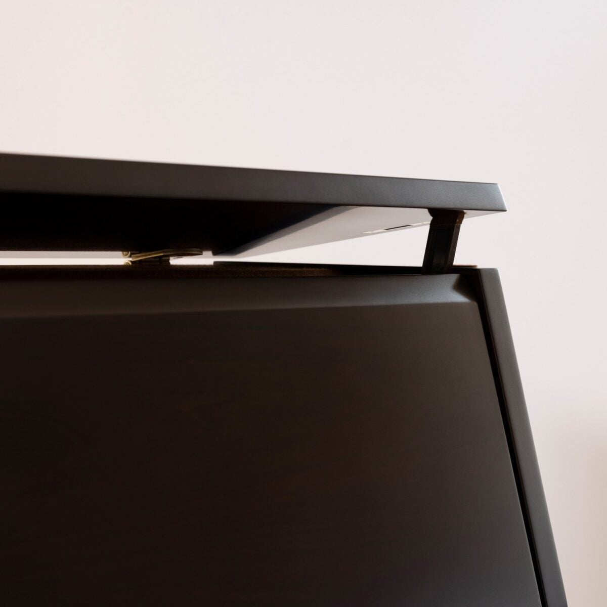 Piano lid hinge detail showcasing the sleek, modern design of Classic Pianos Seattle's high-quality instruments.