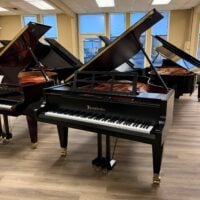 Bösendorfer grand piano in black finish, showcasing premium craftsmanship and rich tonal quality in a showroom setting.