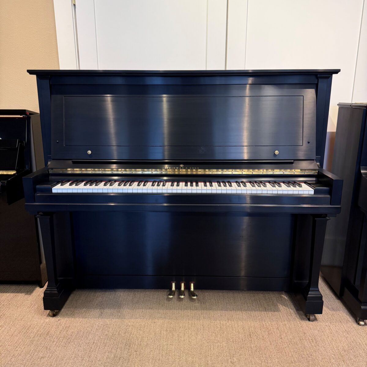 Classic upright piano with a rich ebony finish, polished keys, and detailed craftsmanship. Ideal for any music space.