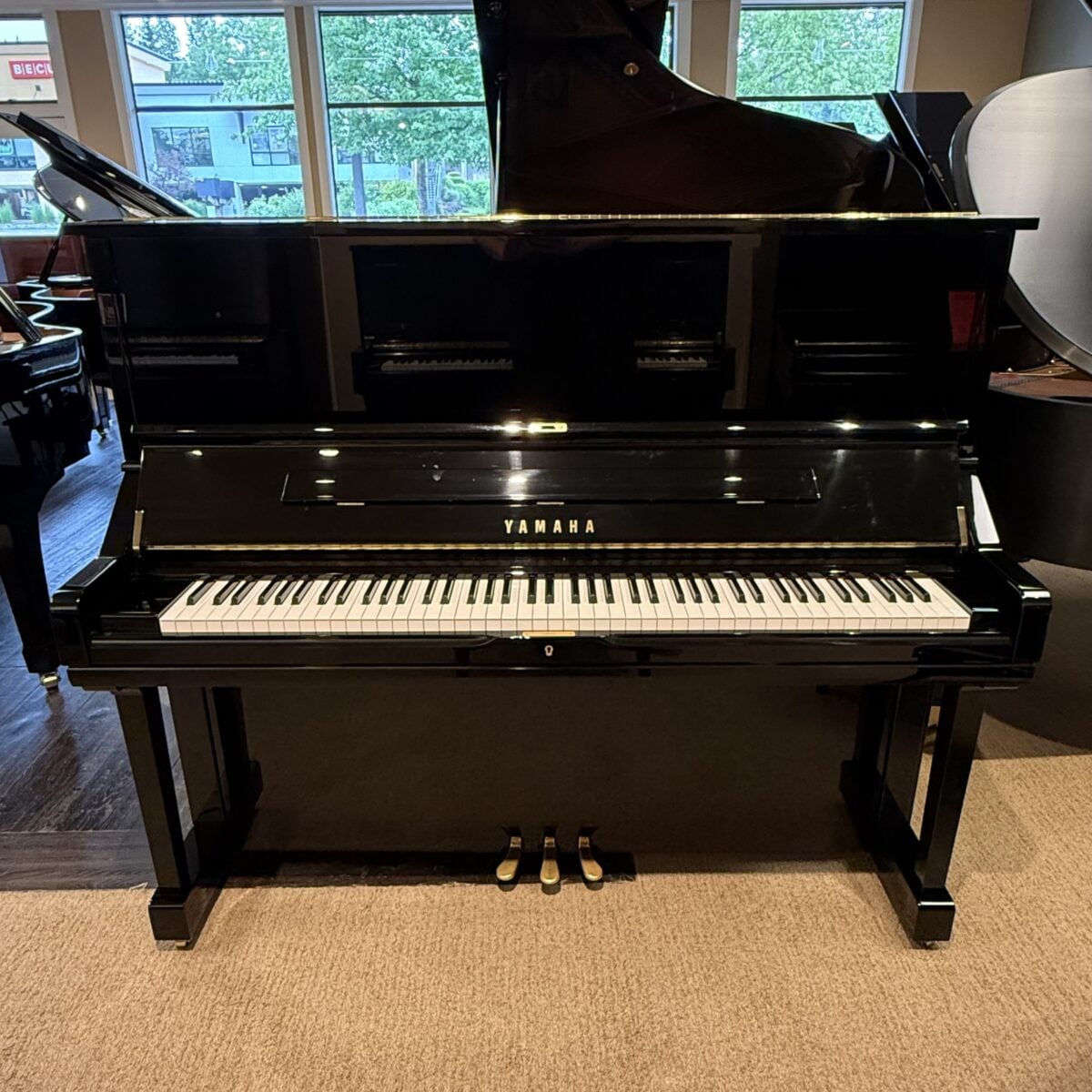 Yamaha upright piano with polished ebony finish, showcasing a sleek design and precision craftsmanship at Classic Pianos Seattle.