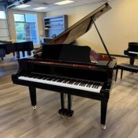 Yamaha grand piano showcasing polished ebony finish and precision-engineered keys, perfect for any classical music setting.