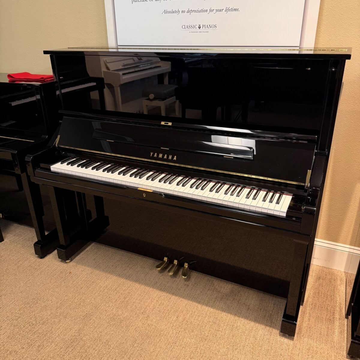 Yamaha upright piano with a polished ebony finish, featuring responsive keys and durable brass pedals for optimal performance.