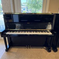 Yamaha U1 upright piano in polished ebony finish, featuring an expressive keyboard and advanced tonal quality.