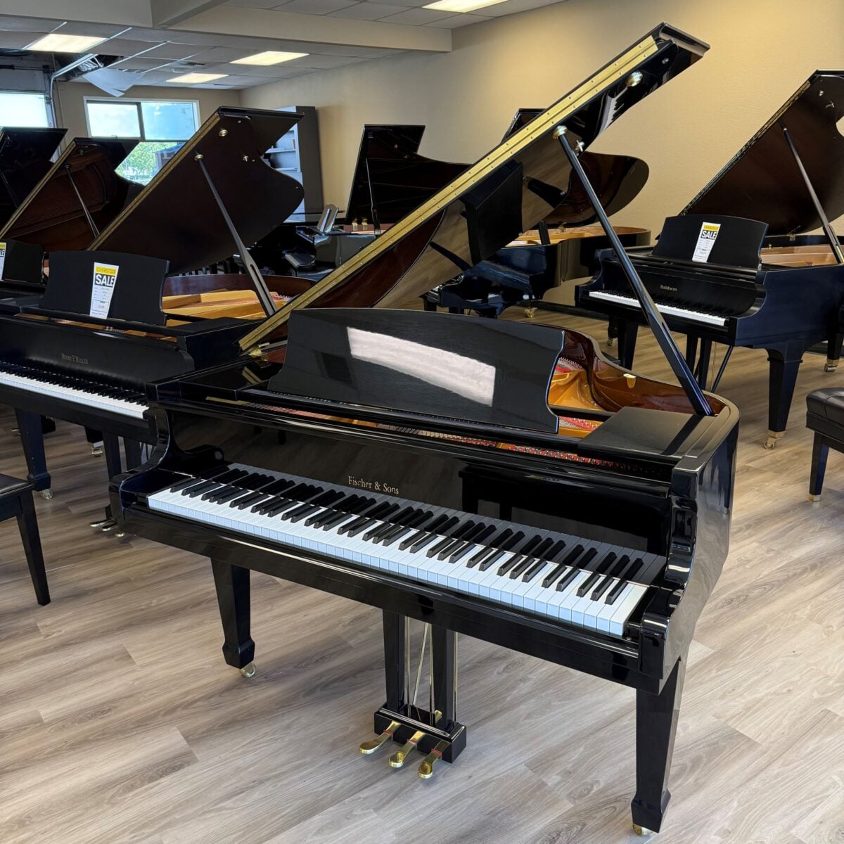 Elegant Fisher & Sons grand piano, polished black finish, showcasing a sophisticated design and premium craftsmanship.
