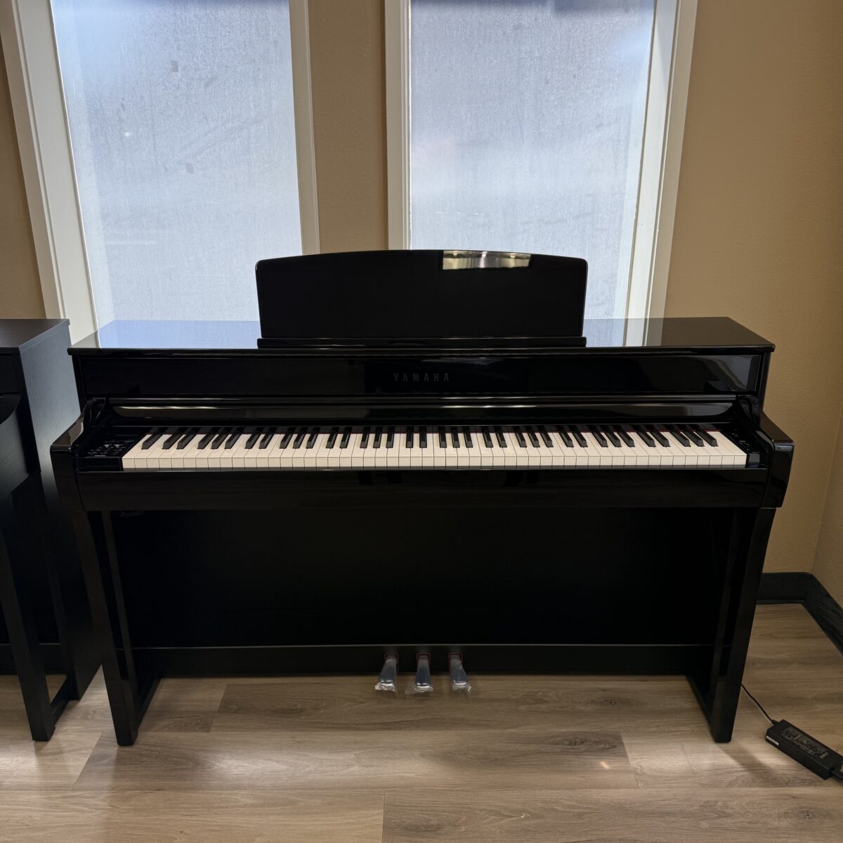Yamaha digital piano with a polished black finish, featuring weighted keys for authentic playing experience. Ideal for beginners.